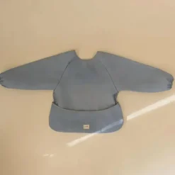 Mushie Baby Coats, Sweaters & Jackets*- Long Sleeve Baby Bib, Waterproof Fabric, Adjustable Fit for Ages 6-24 Months, Tradewinds