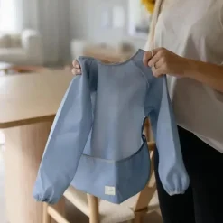 Mushie Baby Coats, Sweaters & Jackets*- Long Sleeve Baby Bib, Waterproof Fabric, Adjustable Fit for Ages 6-24 Months, Tradewinds